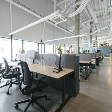 Inside shot of new open space office with colorful furniture on workplace and light from windows