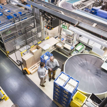 Top view of two men talking in factory shop floor